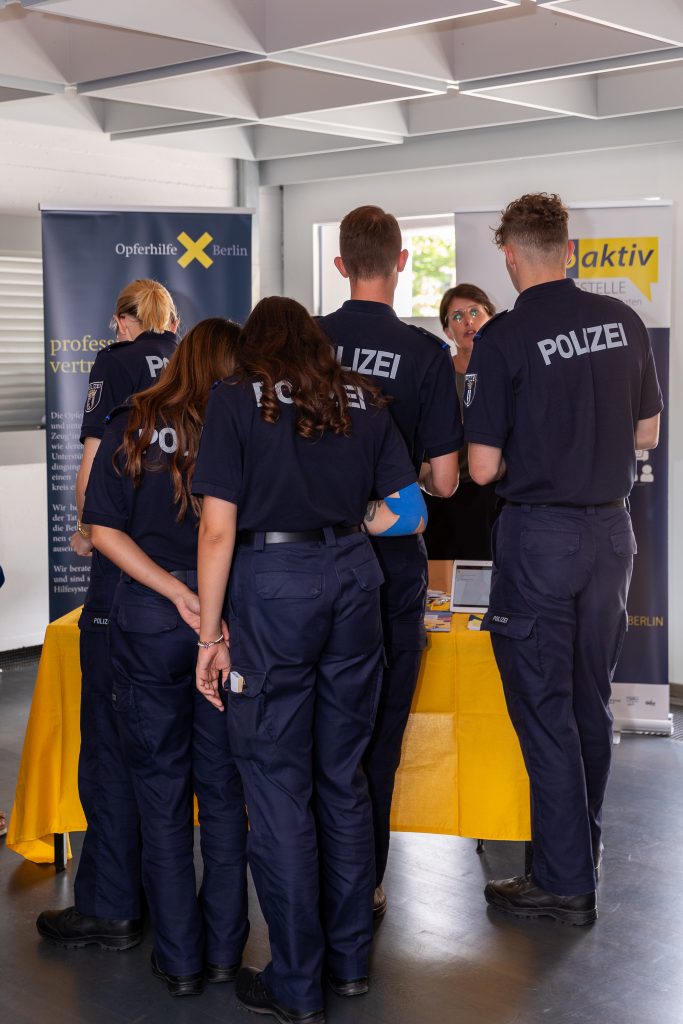 Zu sehen ist der proaktiv-Infostand, vor dem viele Polizeinachwuchskräfte stehen.